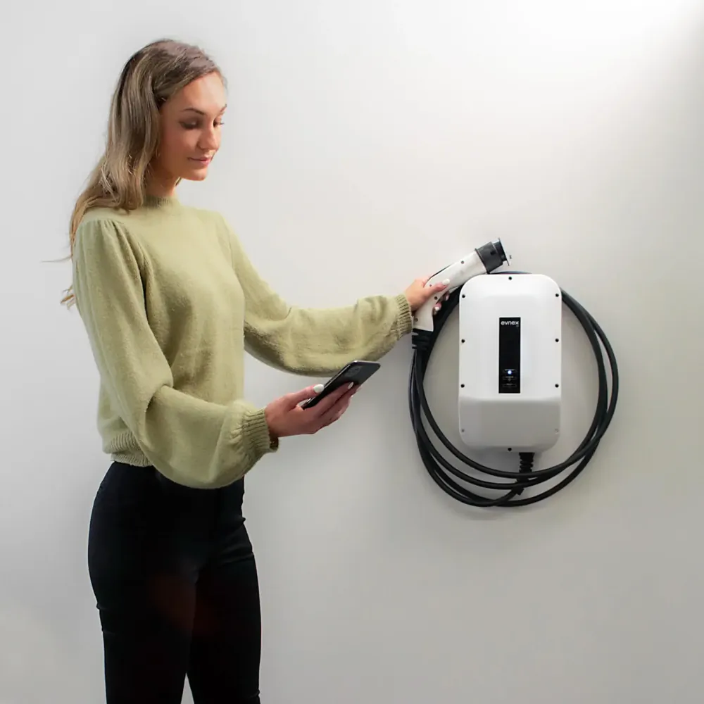 Women charging an EV with an Evnex X22 installed on a light-coloured brick wall